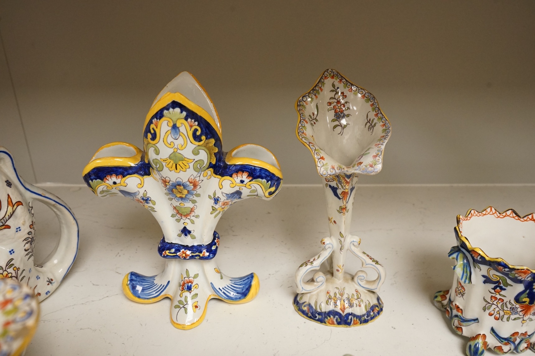 A group of French faience pottery to include spill vases, an ink well and dishes, largest 21cm high